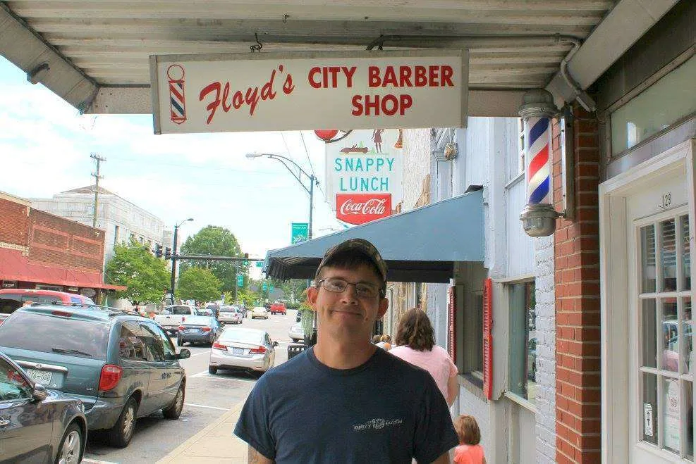 Man standing outside Floyd's Barber Shop in Mount Airy, North Carolina