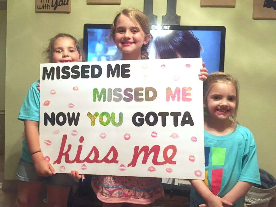 girls making a deployment homecoming sign