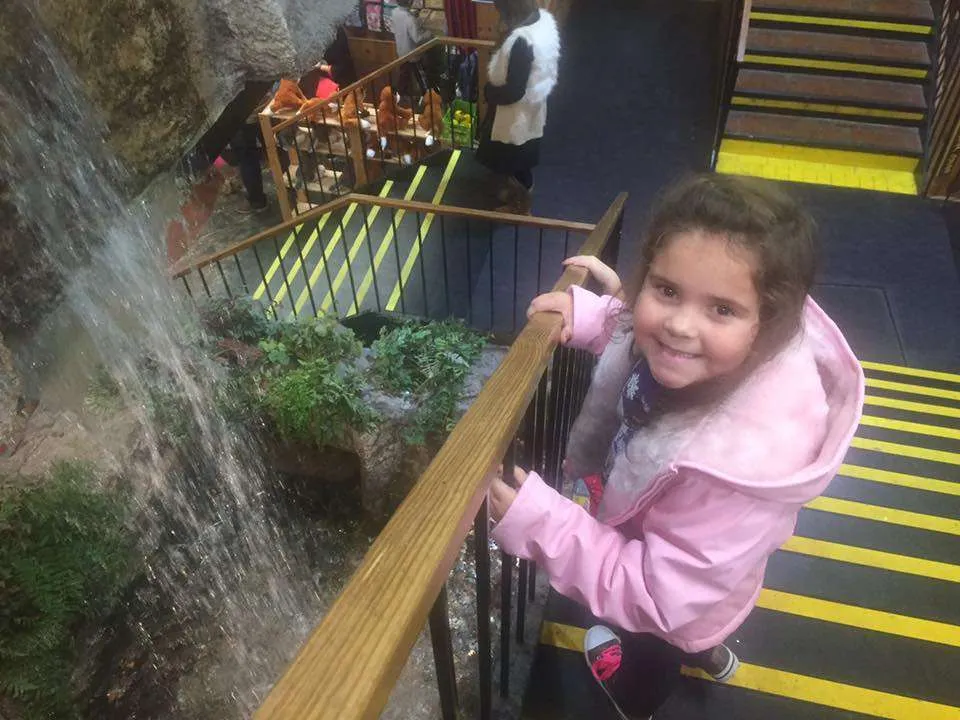 girl beside the waterfall at the Smoky Mountain Works store in Sevierville, TN
