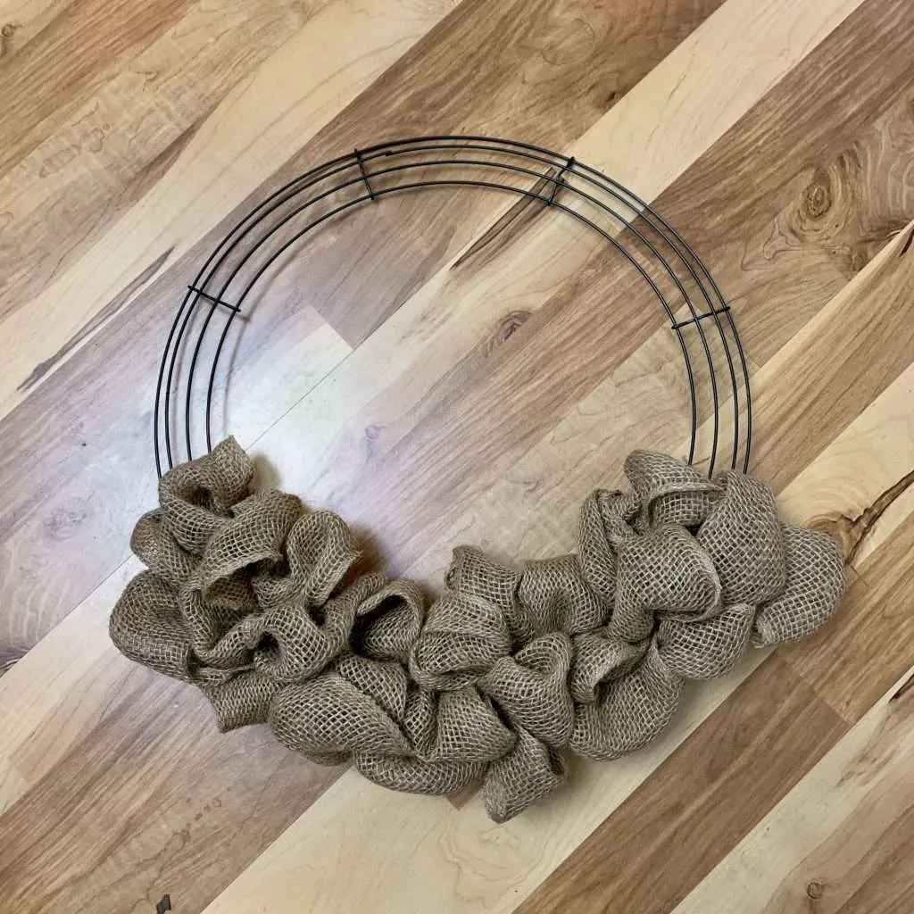 Step 2 of making a Christmas wreath is to add brown burlap to the wreath form. 
