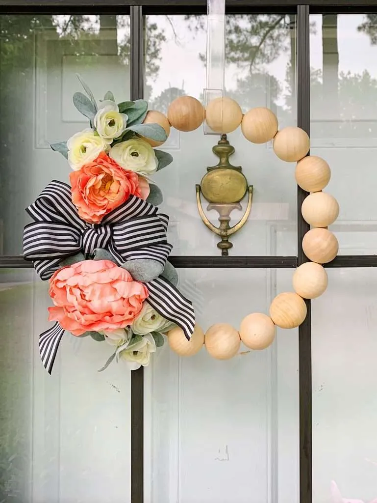 The final step to this DIY wood bead wreath is to add a bow!
