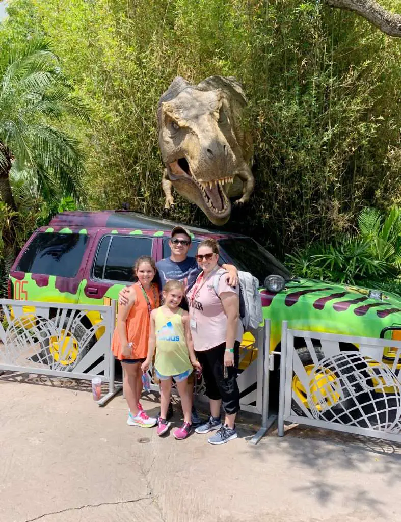 A family photo with a t-rex at Jurassic Park in Islands of Adventure.