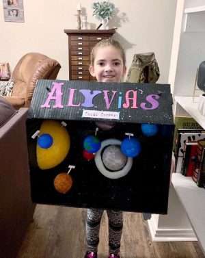 Taking her model solar system to school!