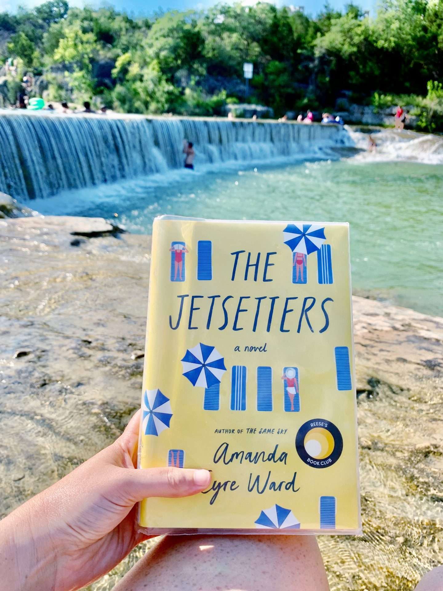 Reading the novel 'Jetsetters' while the kids swim in the San Gabriel river.