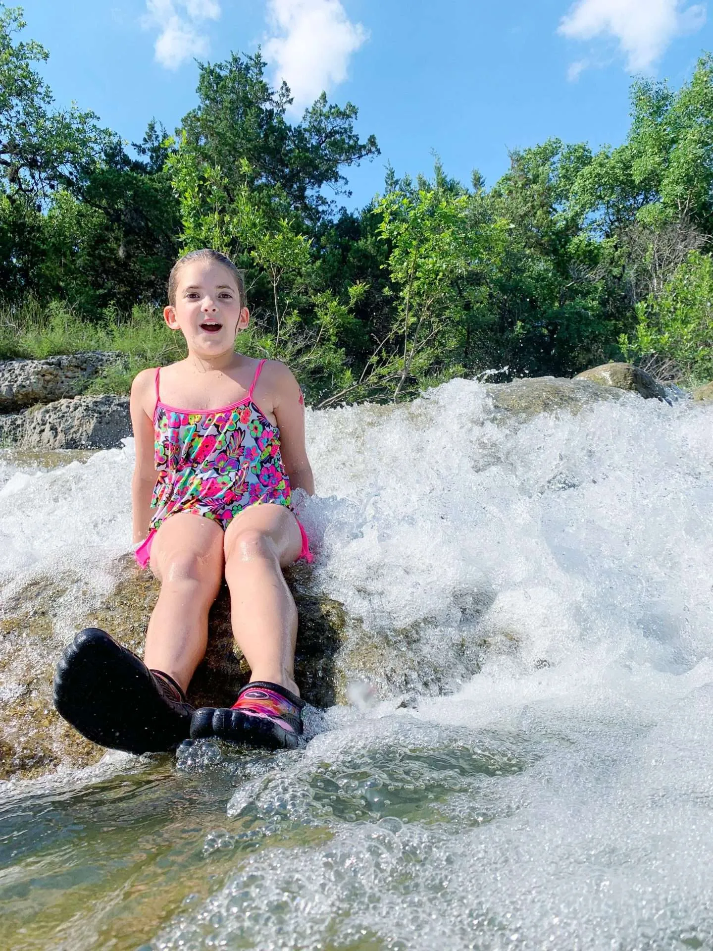 Girl playing in a waterfall in Texas.