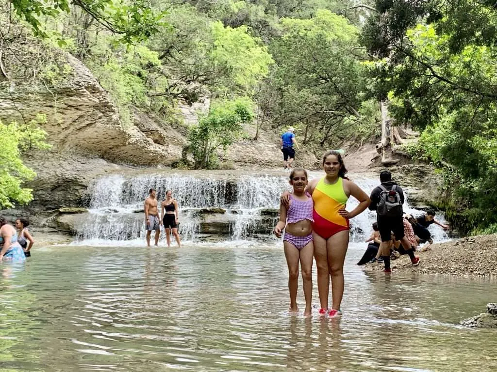 People swimming in the river at Chalk Ridge Falls in Belton, TX.