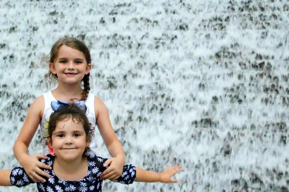 Girls in front of water wall in Houston, TX.