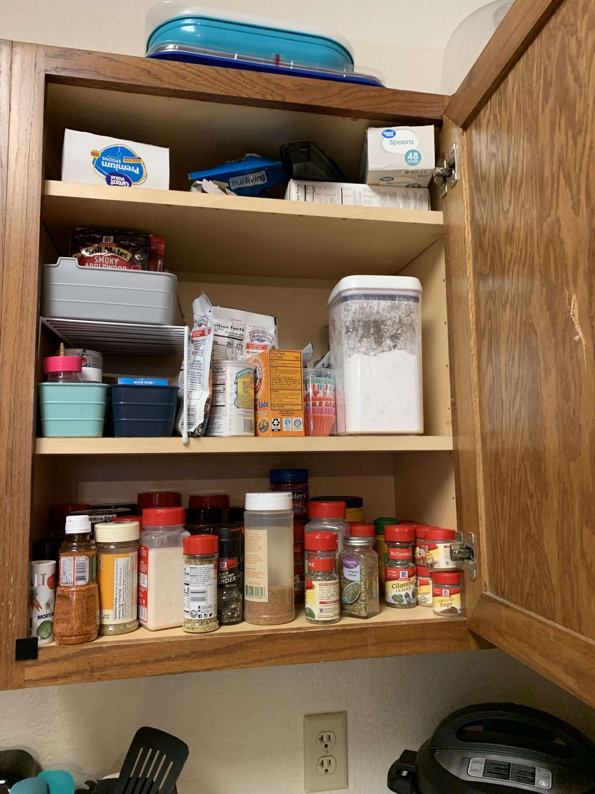 The before picture of my messy spice cabinet