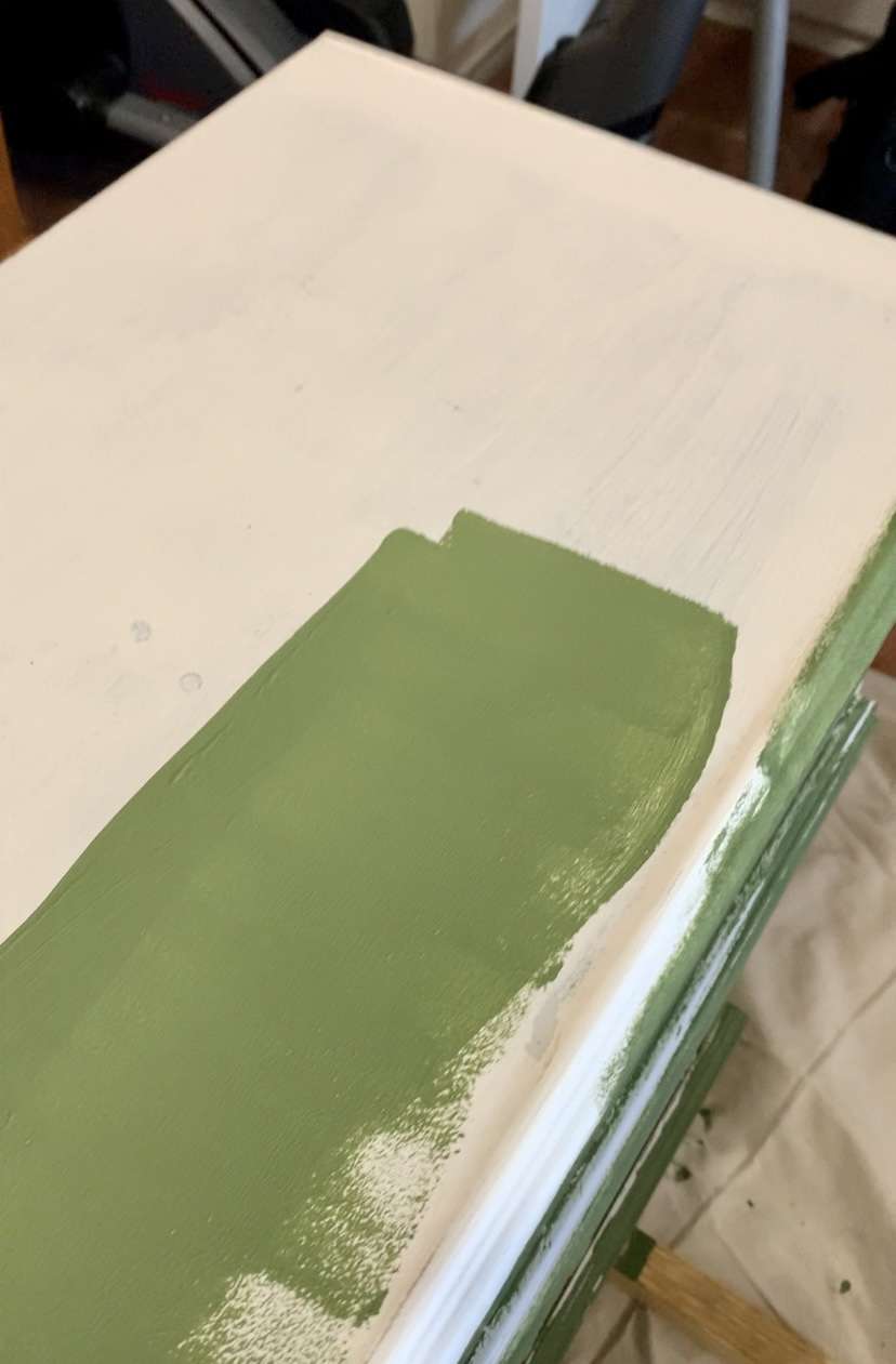 Painting a dresser green.