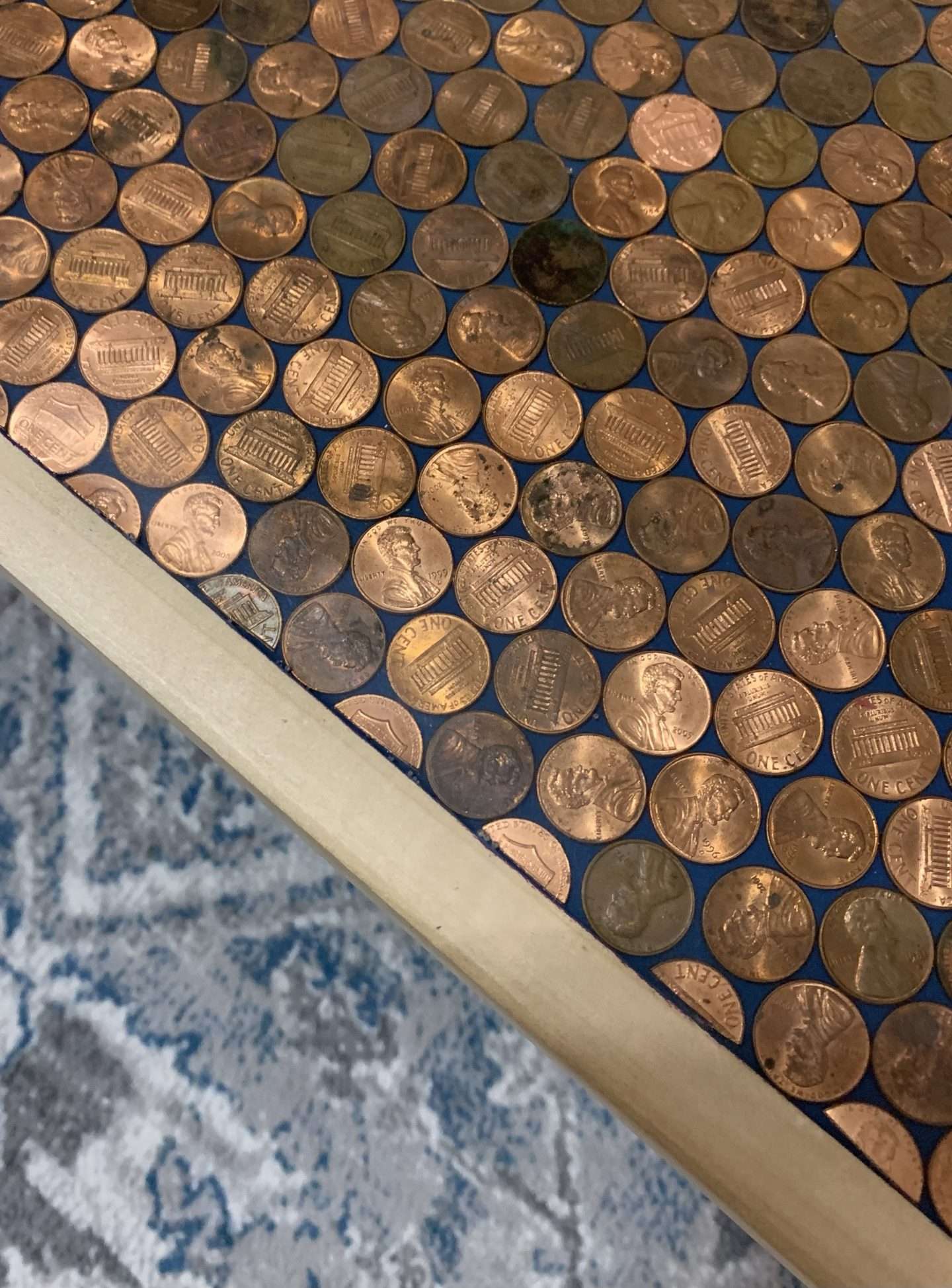 We cut pennies with tin snips to fit in the edges of the penny coffee table.
