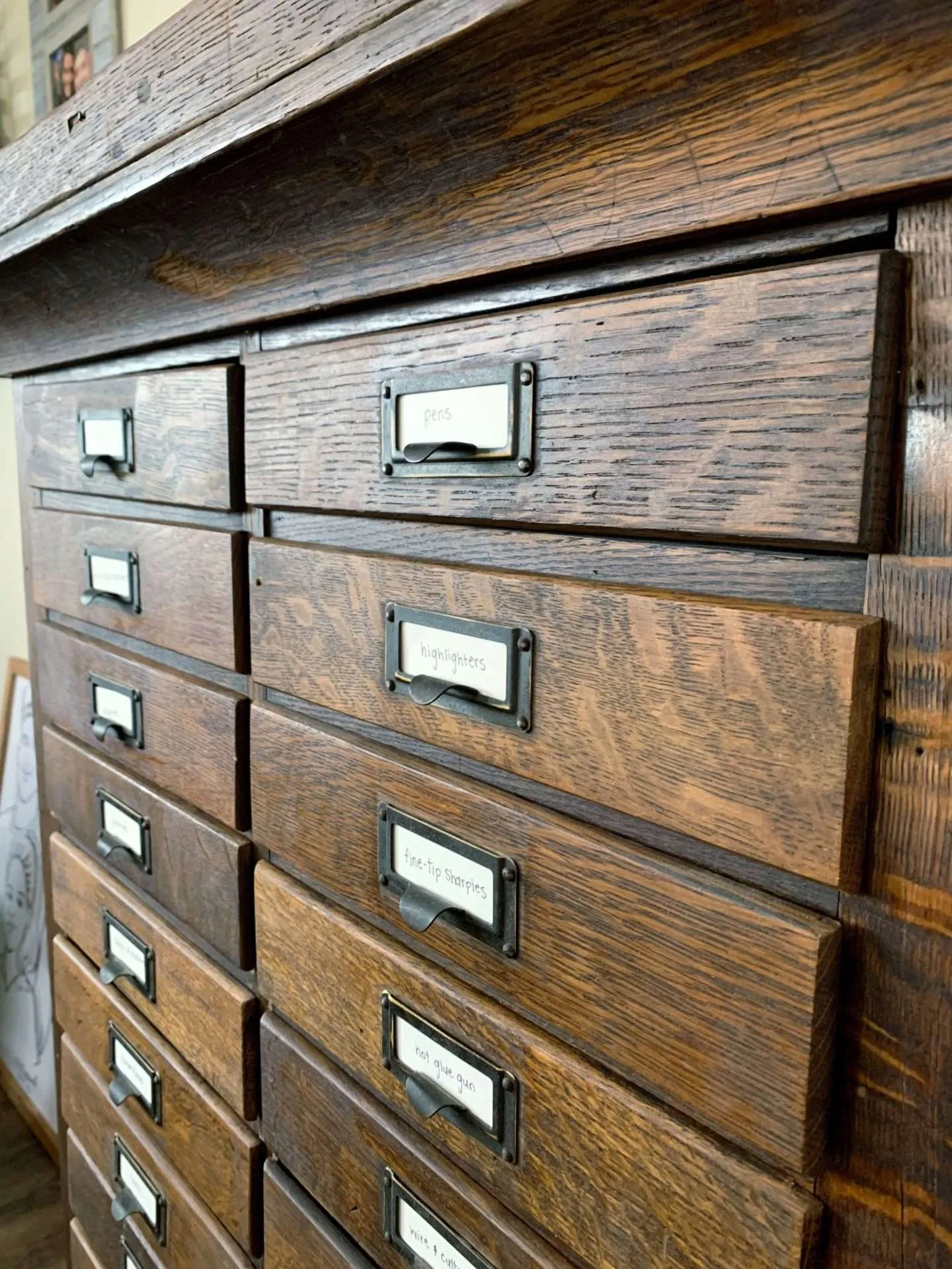 Drawers and labels on an antique hardware cabinet.