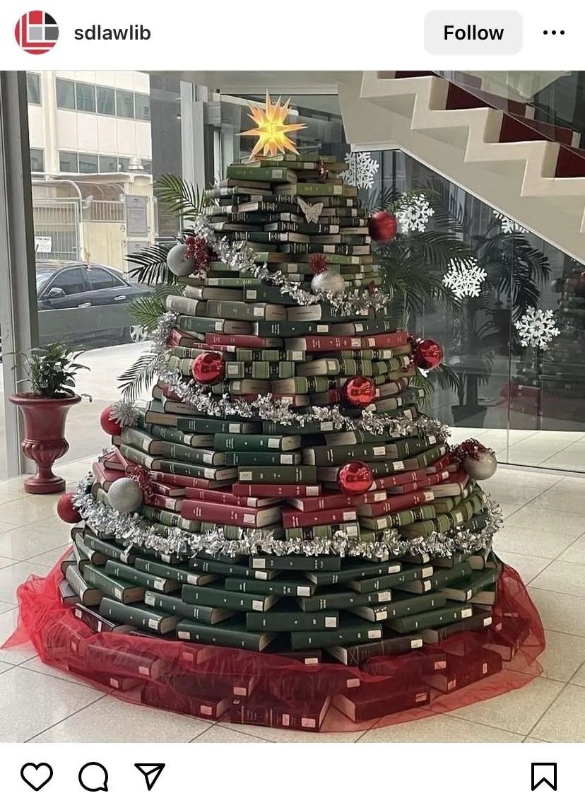 Bookmas tree ideas: giant stack of books in the shape of a Christmas tree at a law library.