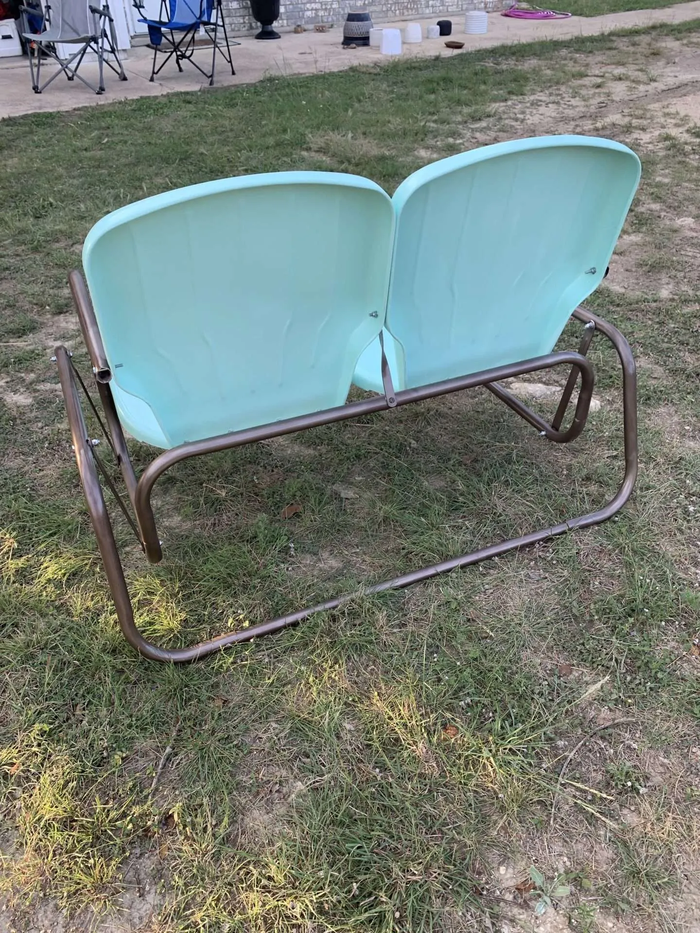 The back of a vintage metal glider that has been repainted.